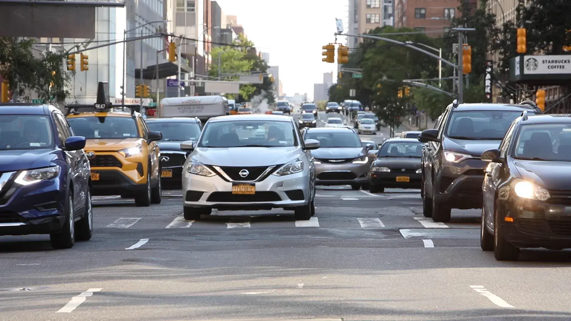 A busy city street filled with cars during traffic congestion, representing city driving conditions.