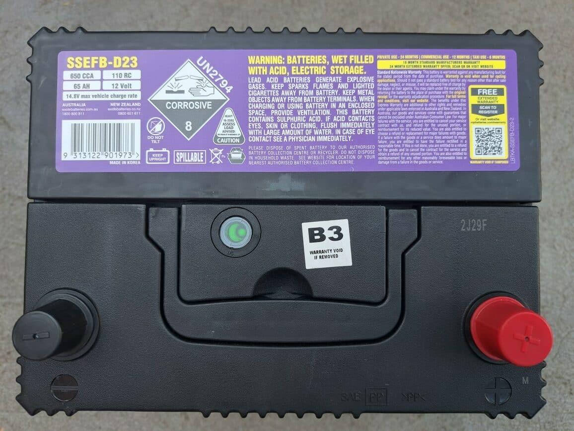 Close-up of a car battery label showing manufacturing date and specifications.