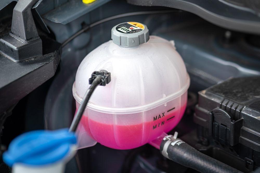 Close-up of a car's coolant reservoir showing coolant levels, crucial for maintaining proper heater function.