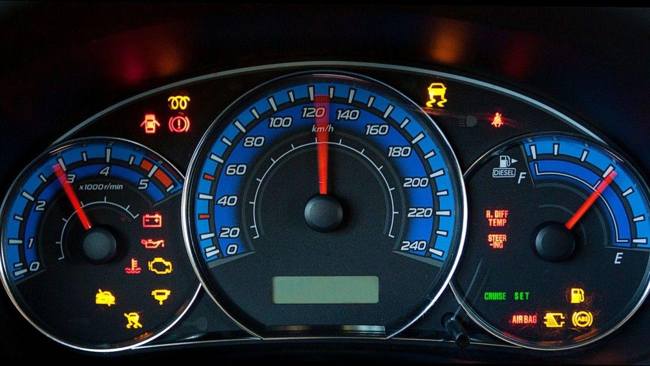 Car dashboard with multiple warning lights indicating potential Diagnostic Trouble Codes (DTCs).