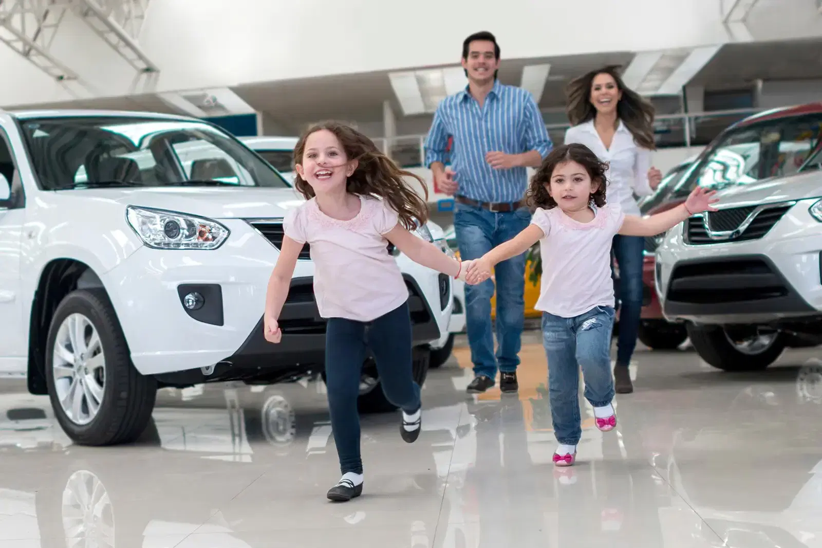 family-car-purchasing-dealership-running-smiling.webp