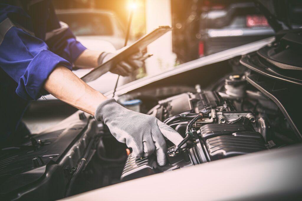 A professional mechanic inspecting a used car engine, checking for accidents.